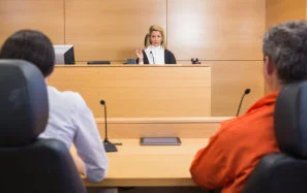 Lawyer and client listening to judge in the court room