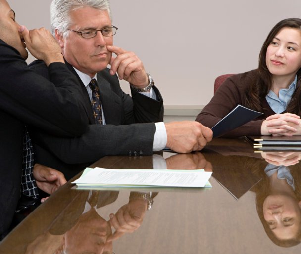 a group of people in the meeting while a man whispers to a man's ear.