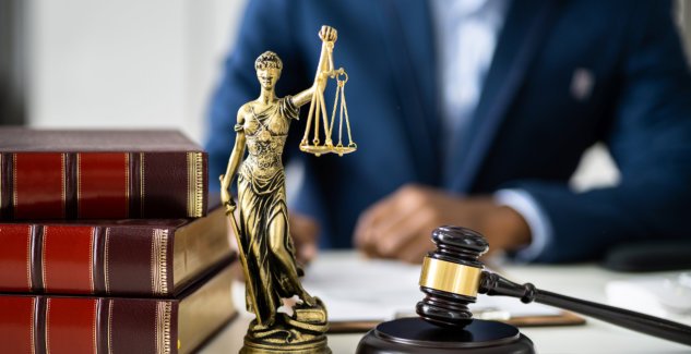 Lady Justice statue with books and gavel on the side